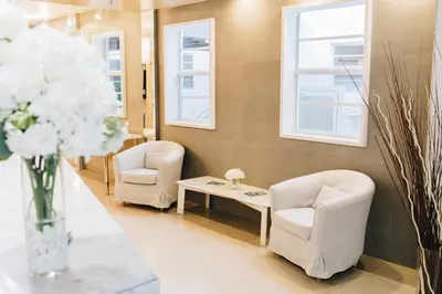 a waiting room with two chairs and a table and flowers at Ocean Reef Suites in Miami Beach