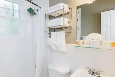 a bathroom with a toilet and a sink and a mirror at Ocean Reef Suites in Miami Beach