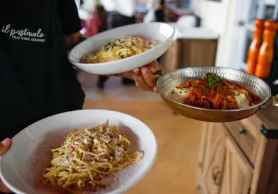 a person holding two bowls of food on a counter at Ocean Reef Suites in Miami Beach