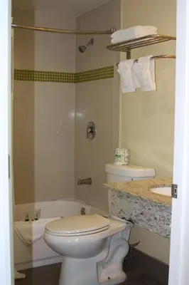 a bathroom with a toilet and a tub and a sink at The Hollywood Gateway Inn in Hollywood