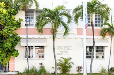 a building with palm trees in front of it at Riviere South Beach Hotel in Miami Beach