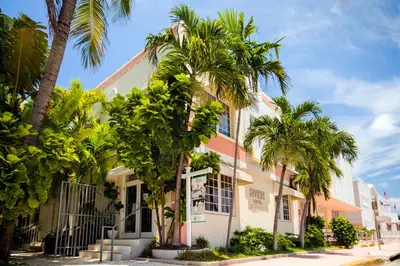 a building with palm trees in front of it at Riviere South Beach Hotel in Miami Beach