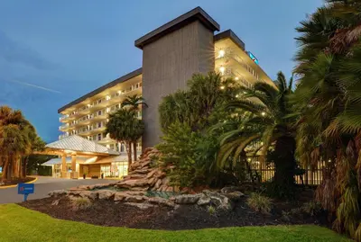a building with palm trees in front of it at Motel 6-Cutler Bay, FL in Cutler Bay