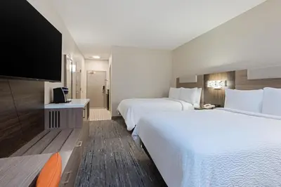 a hotel room with two beds and a flat screen tv at Holiday Inn Express Hotel & Suites Ft. Lauderdale-Plantation by IHG in Plantation
