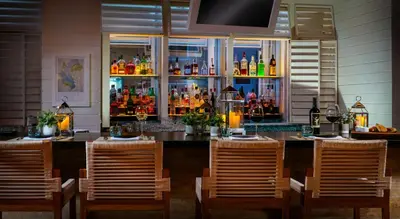 a bar with four chairs and a counter with drinks at Sole Miami, A Noble House Resort in Miami Beach