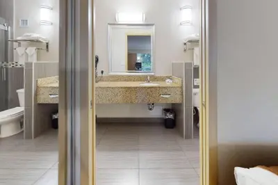 a bathroom with two sinks and a mirror at Rodeway Inn & Suites Fort Lauderdale Airport & Cruise Port in Fort Lauderdale