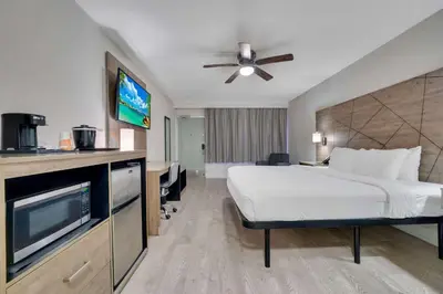 a hotel room with a bed and a flat screen tv at Quality Inn & Suites Airport-Cruise Port Hollywood in Hollywood