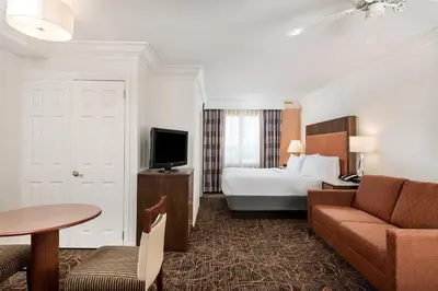 a hotel room with a bed and a couch at Holiday Inn Fort Lauderdale Airport by IHG in Hollywood