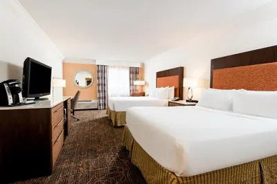 a hotel room with two beds and a flat screen tv at Holiday Inn Fort Lauderdale Airport by IHG in Hollywood