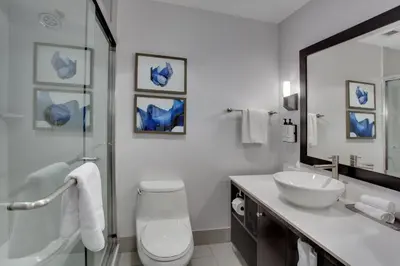 a bathroom with a toilet and a sink and a mirror at Crowne Plaza Hotel & Resorts Fort Lauderdale Airport/ Cruise by IHG in Fort Lauderdale