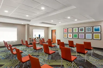 a conference room with orange chairs and a table at Holiday Inn Express & Suites Pembroke Pines-Sheridan St by IHG in Pembroke Pines