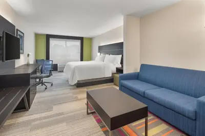 a hotel room with a bed and a couch at Holiday Inn Express & Suites Pembroke Pines-Sheridan St by IHG in Pembroke Pines