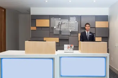 a man is standing behind a podium in a room at Holiday Inn Express Hotel & Suites Fort Lauderdale Airport/Cruise Port by IHG in Fort Lauderdale