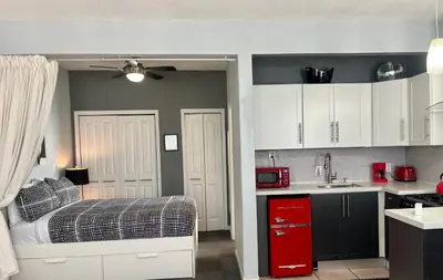 a bedroom with a bed and a kitchen with white cabinets at Ocean Dream in Miami Beach