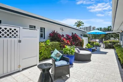 a patio with a chair and plants and an umbrella at Hollywood Beach Suites and Hotel in Hollywood