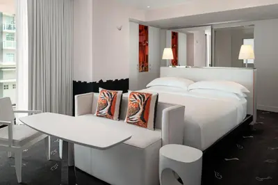 a bedroom with a white bed and a table and chair at Dua Miami, Autograph Collection in Miami