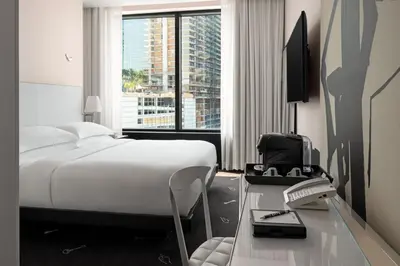 a hotel room with a bed and a desk with a phone at Dua Miami, Autograph Collection in Miami