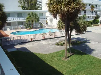 a swimming pool in a resort with a palm tree at Collins Hotel in Miami Beach