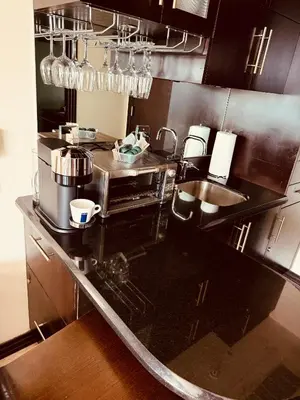 a kitchen with a sink and a coffee maker at Apartment at De Soleil Hotel on Ocean Drive in Miami Beach