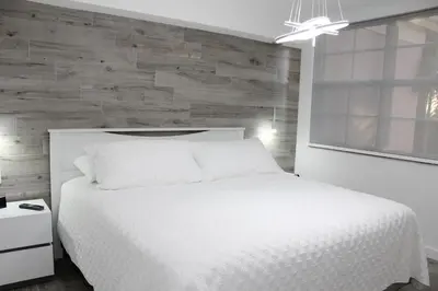 a bedroom with a white bed and a wooden wall at Yacht Club at Aventura Luxurious 1 Bed 1 Bath in Aventura