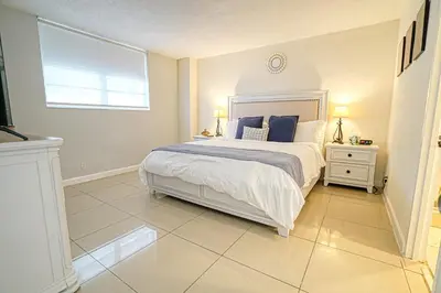 a bedroom with a bed with blue pillows and a window at Hollywood apartment by the sea in Hollywood