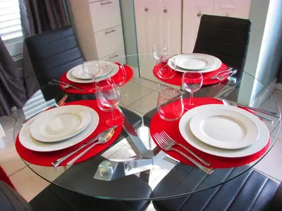 a glass table with red plates and wine glasses on it at Ocean Breeze in Miami Beach