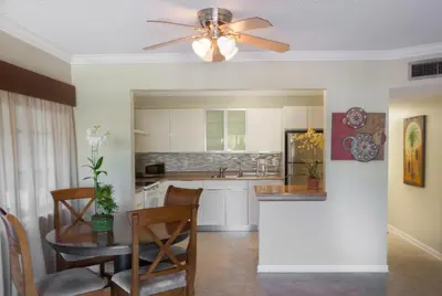 a kitchen with a ceiling fan and a table at The Big Coconut Guesthouse - Gay Men's Resort in Fort Lauderdale