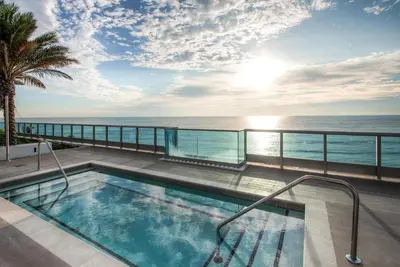 a swimming pool with a view of the ocean at Global Luxury Suites at Monte Carlo in Miami Beach