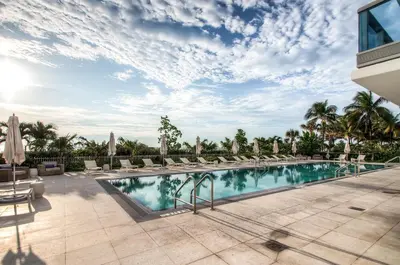 a swimming pool with lounge chairs and umbrellas at Global Luxury Suites at Monte Carlo in Miami Beach