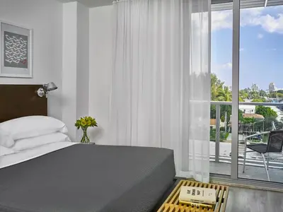 a bedroom with a bed and a large window at ABAE Hotel by Eskape Collection in Miami Beach