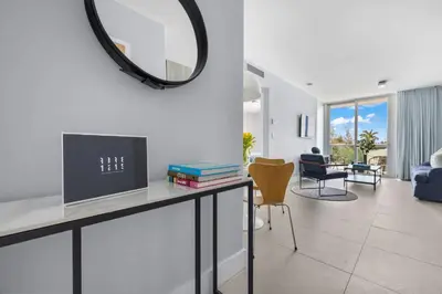 a living room with a table with a tv and a mirror at ABAE Hotel by Eskape Collection in Miami Beach