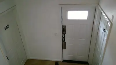 an empty hallway with a white door and a window at Fatimataj Mahal in Miami