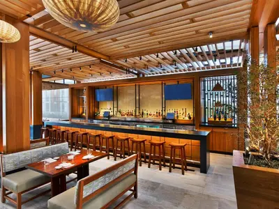 a restaurant with a bar with tables and chairs at Nobu Hotel Miami Beach in Miami Beach
