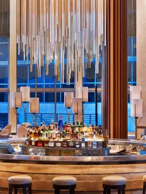 a hotel lobby with a bar with stools at Nobu Hotel Miami Beach in Miami Beach