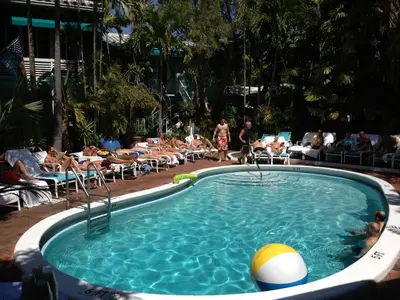 a pool with a ball in the middle of a group of people at Pineapple Point Guesthouse & Resort - Gay Men's Resort in Fort Lauderdale