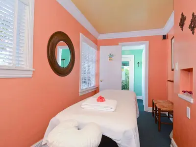 a bedroom with orange walls and a bed with two white pillows at Pineapple Point Guesthouse & Resort - Gay Men's Resort in Fort Lauderdale