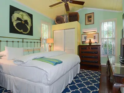 a bedroom with a large bed with a ceiling fan at Pineapple Point Guesthouse & Resort - Gay Men's Resort in Fort Lauderdale