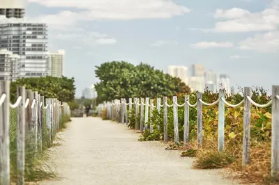 a sidewalk next to a fence with plants at Four Seasons Hotel at The Surf Club in Miami Beach