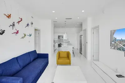 a living room with a blue couch and a yellow chair at Modern Penthouse condo with 2 Large private terraces in Hollywood