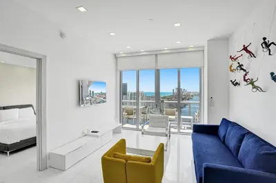 a living room with a blue couch and a bed at Modern Penthouse condo with 2 Large private terraces in Hollywood