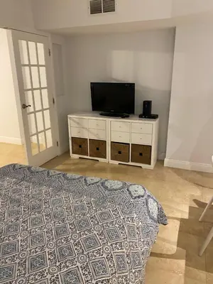 a bedroom with a bed and a flat screen tv at Ocean Front Studio Units in Miami Beach