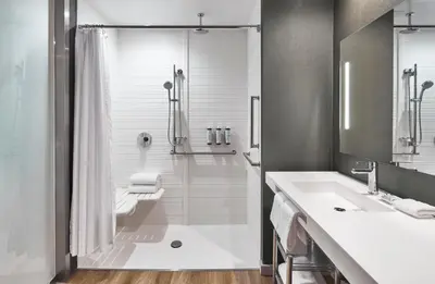 a white bathroom with a shower and a sink at AC Hotel by Marriott Miami Aventura in Aventura