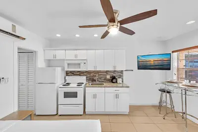 a kitchen with white appliances and a ceiling fan at The Sunrise in Hollywood