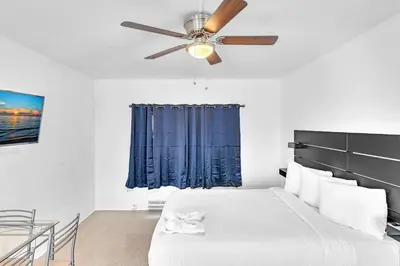 a bedroom with a bed and a ceiling fan at The Sunrise in Hollywood