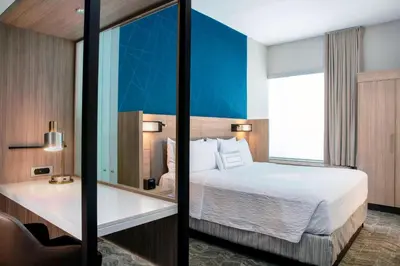 a hotel room with a bed and a mirror at SpringHill Suites by Marriott Miami Doral in Miami