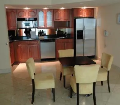 a kitchen with a table and chairs and a refrigerator at The Fritz Hotel in Miami Beach