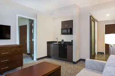 a hotel room with a kitchen and a living room at Wingate by Wyndham Miami Airport in Miami
