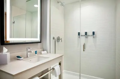 a white bathroom with a sink and a shower at Four Points by Sheraton Miami Airport in Miami