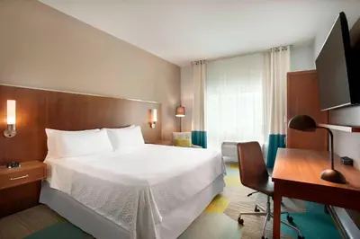a bedroom with a bed and a desk and a computer at Four Points by Sheraton Miami Airport in Miami