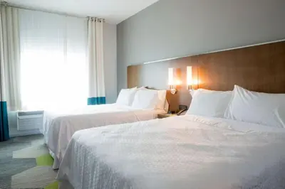 a hotel room with two beds and a window at Four Points by Sheraton Miami Airport in Miami